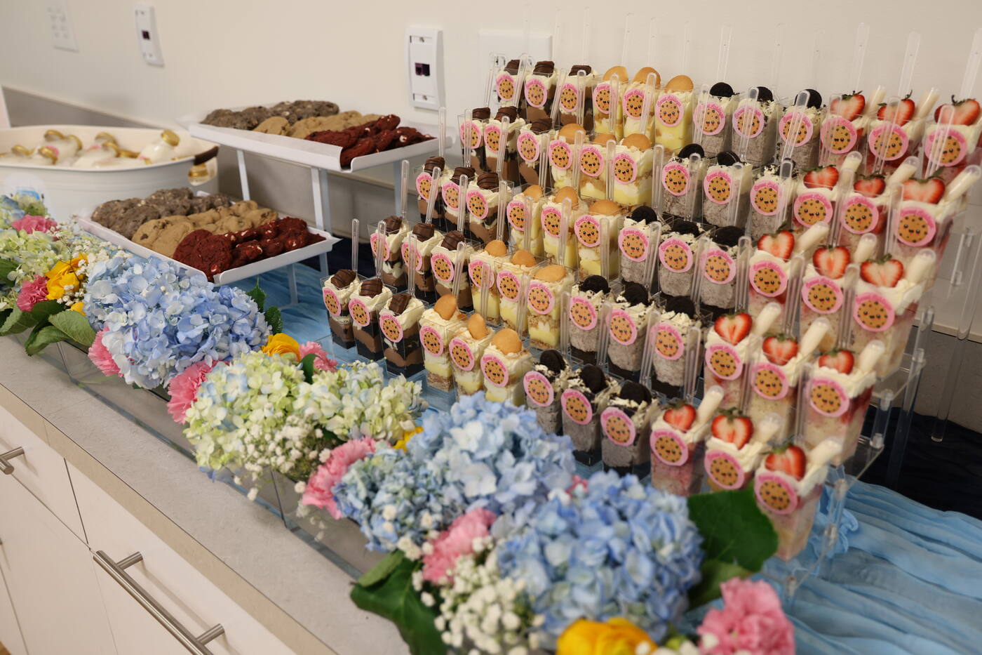 Full table of cookies, dessert cups, and milk shots